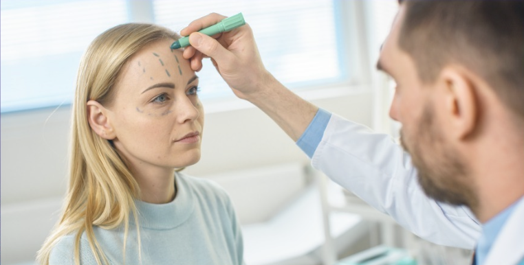 BAAPS doctor marking up woman's face with pen