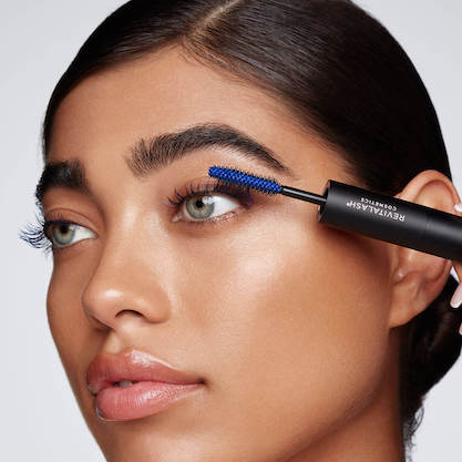 Close up of woman applying Revitalash blue mascara