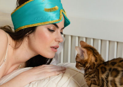 Woman next to kitten wearing Embellished Drowsy Sleep Co Sleep Mask