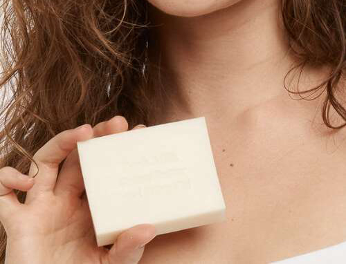 Image of a woman holding a moogoo fresh milk cleansing bar